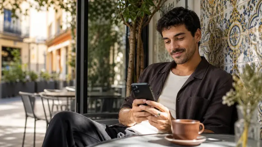 Privacidad con control Usuario adulto español gestionando un álbum privado de Menta Social en una cafetería de Madrid